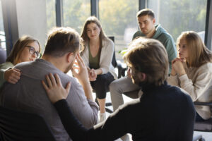 grupa siedzących kręgu ludzi kobiet i mężczyzn wspierających się